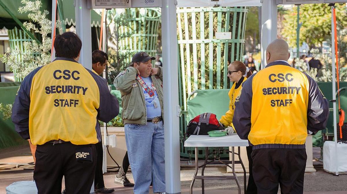 Una persona se retira su broche de metal de Disney mientras pasa por un detector de metales cuando entra a los parques temáticos el jueves 17 de diciembre de 2015 en Anaheim, California.