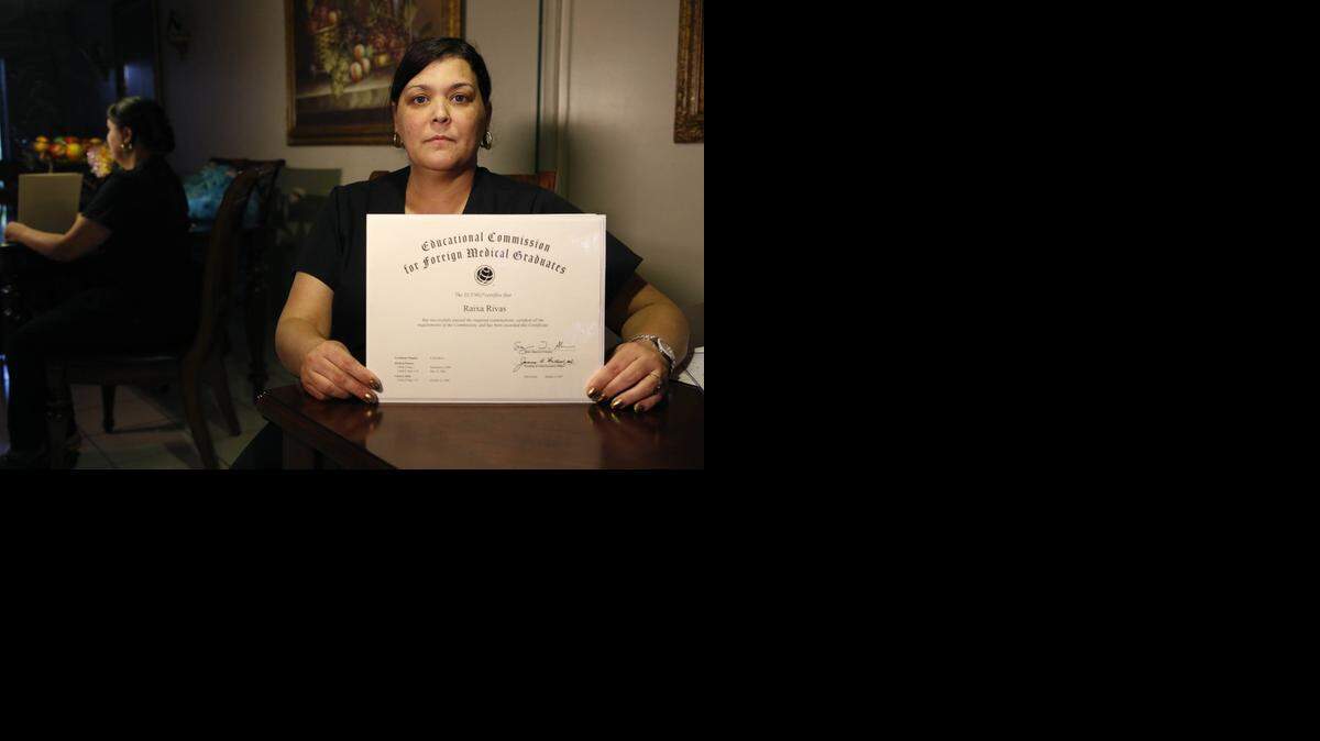 
La doctora Raixa Rivas, en su casa de Hialeah Gardens, sostiene el documento que certifica que aprobó los exámenes de revalidación de revalidación de su licencia médica.

