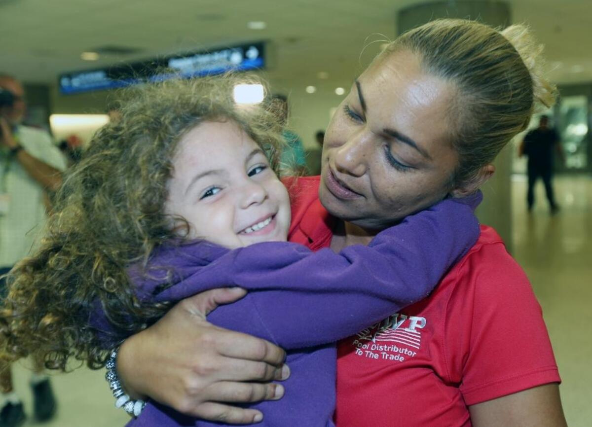 Mara Moreno da un largo abrazo a su nieta, Wilyanielis, de 3 años, en el Aeropuerto Internacional de Miami. La niña llegó de Puerto Rico el martes.
