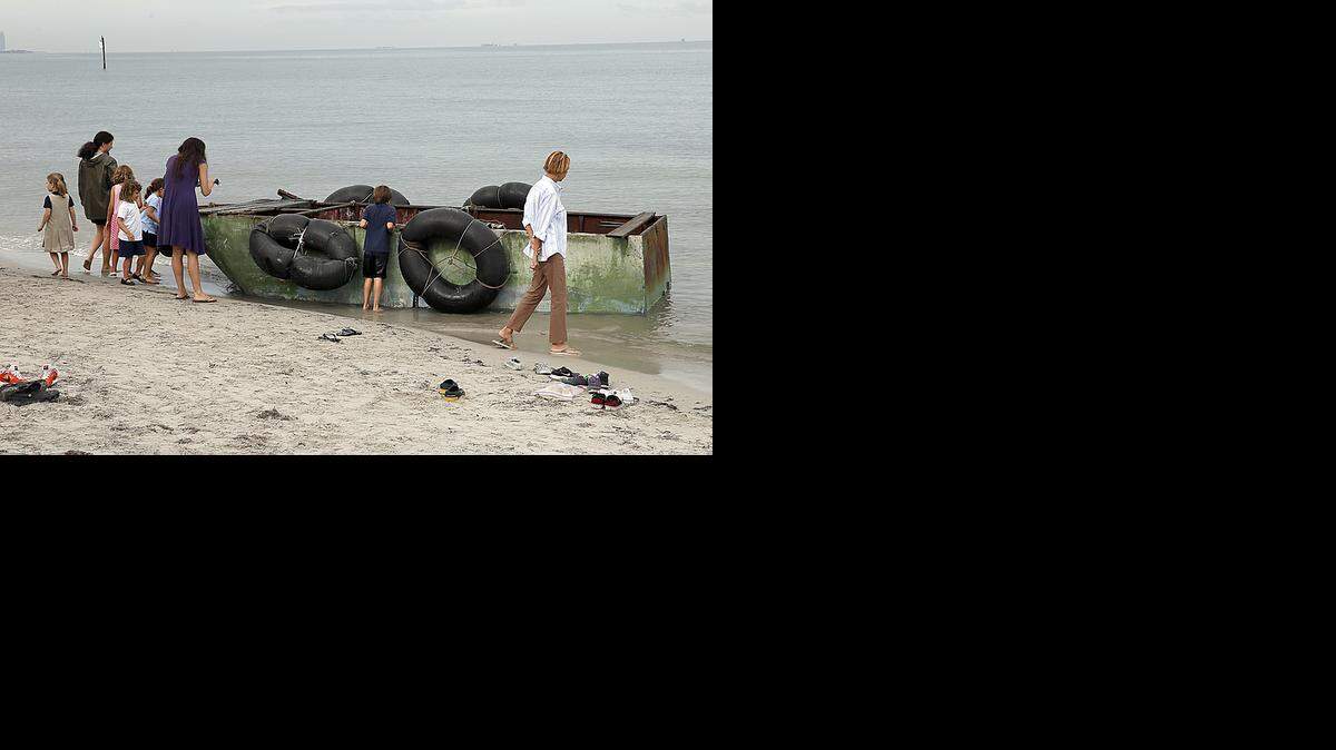 
Un grupo de residentes toma fotografías de la balsa que trajo a nueve inmigrantes cubanos ea las playas de Miami. Foto de archivo.
