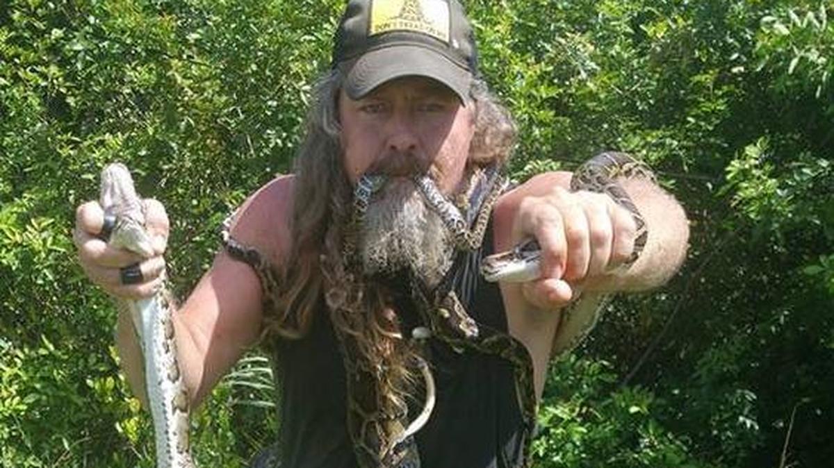 Fotografía sin fecha cedida donde aparece Dustin Crum, conocido en el sur de Florida como “Hombre salvaje”, mostrando una pitón birmana que atrapó en Brandon ubicado en el condado de Hillsborough en Florida.