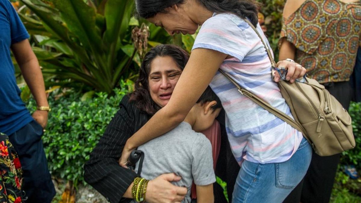 La trabajadora doméstica residente en Estados Unidos Reyna Gómez (cen.) abraza el lunes a amigos tras la decisión del Departamento de Migración y Control de Aduana de Miramar, Broward, de convocarla de nuevo en dos semanas, mientras continúan examinando su caso de petición de asilo.