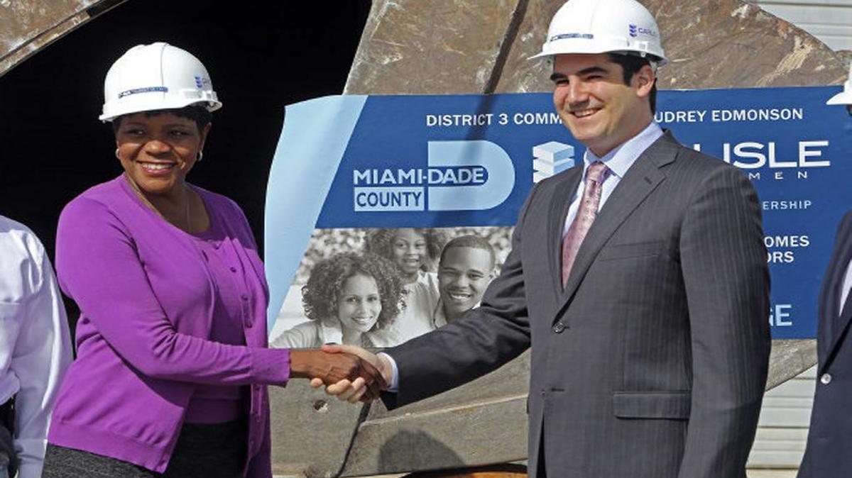 
La comisionada condal Audrey Edmonson estrecha la mano de Matthew Greer, director de Carlisle Development, durante la ceremonia para dar inicio a la construcción de Transit Village. 

