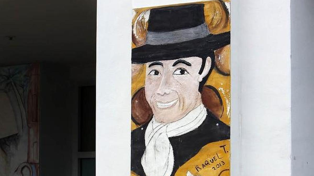 
El promotor Baltasar Martín y la artista Raquel Torrent junto al mural de Carlos Gardel, en CubaOcho Art and Research Center, en La Pequeña Habana.
