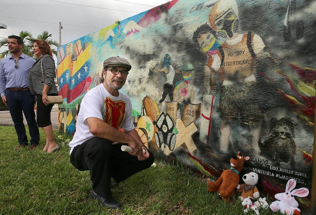 El artista Al Blanco, posa frente a su mural, que honra a las víctimas de las protestas contra la el gobierno de Nicolás Maduro en Venezuela.