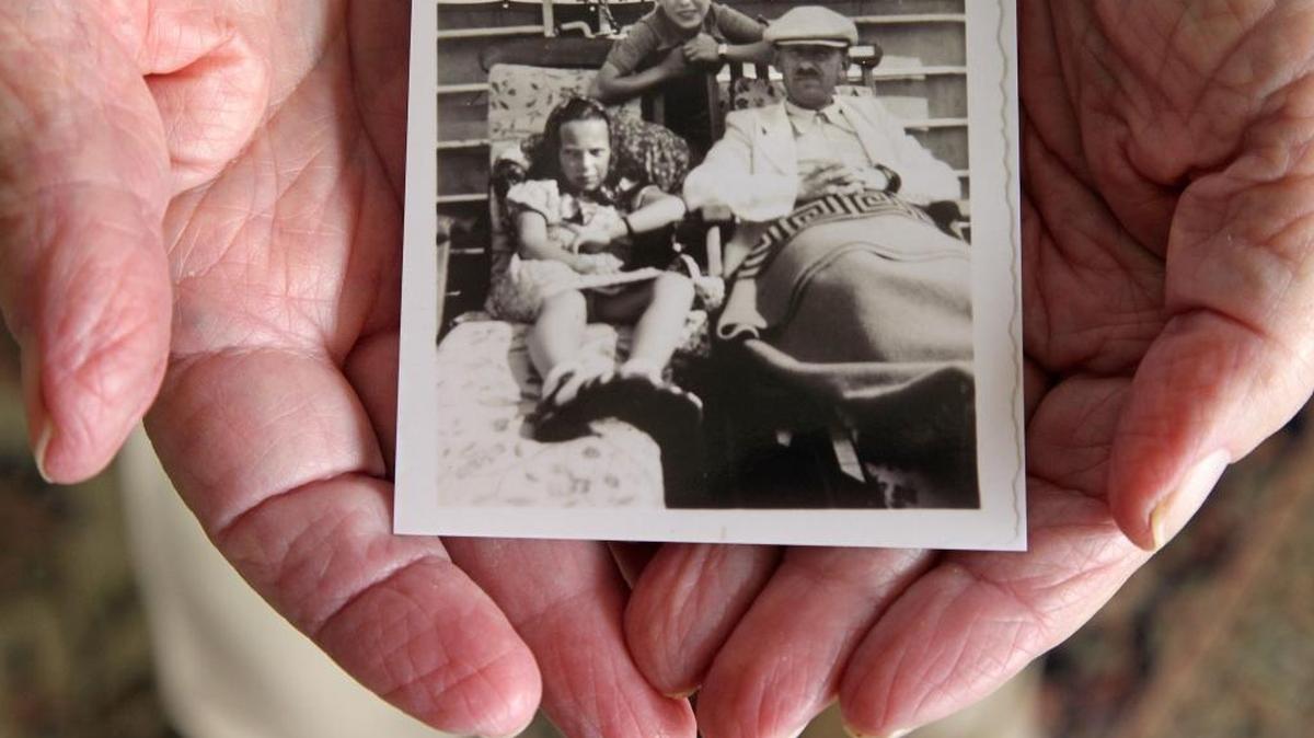 Herbert Karliner muestra una foto de él, a los 12 años, con su hermana Ruth, de 11, y su padre, Joseph Karliner, en el trasatlántico SS St. Louis.