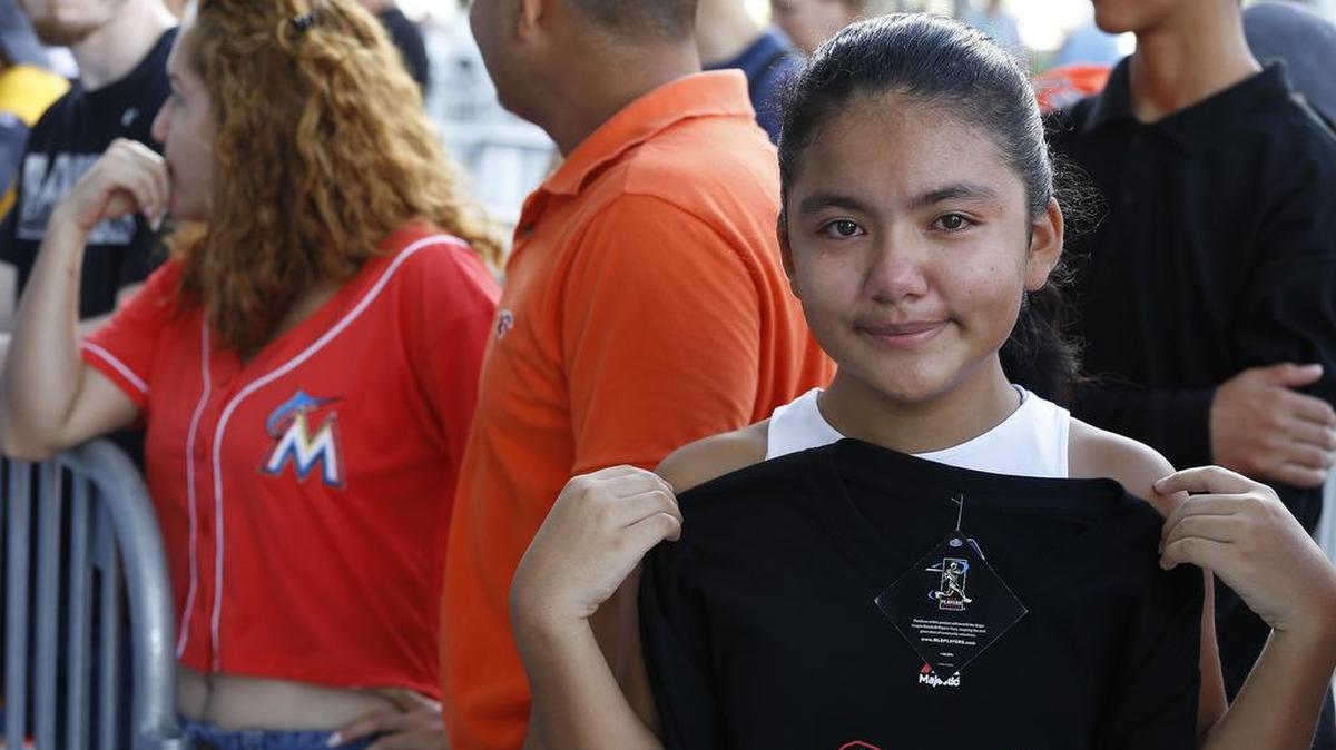 Kelsi Figueroa, de 12 años, contiene las lágrimas al mostrar la camiseta de José Fernández, con el número 16 en el estadio de los Marlins.