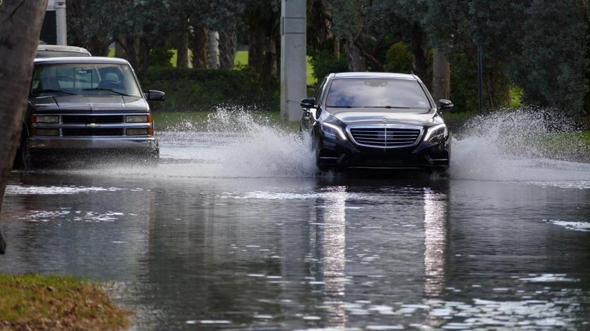 Automóviles circulan por la calle North Bay Road el 27 de octubre, bajo el efecto de la marea real.