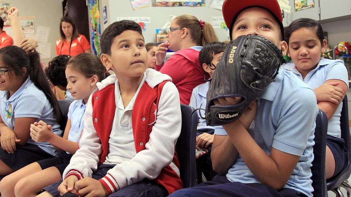 Daryan Paiz y Kevin Barrios, ambos de nueve años, esperan ansiosos la llegada de Marcell Ozuna, jardinero de los Miami Marlins, que este martes realizó una lectura biligüe para estudiantes de cuarto grado en la Primaria Kensington Park, en el noroeste de Miami.