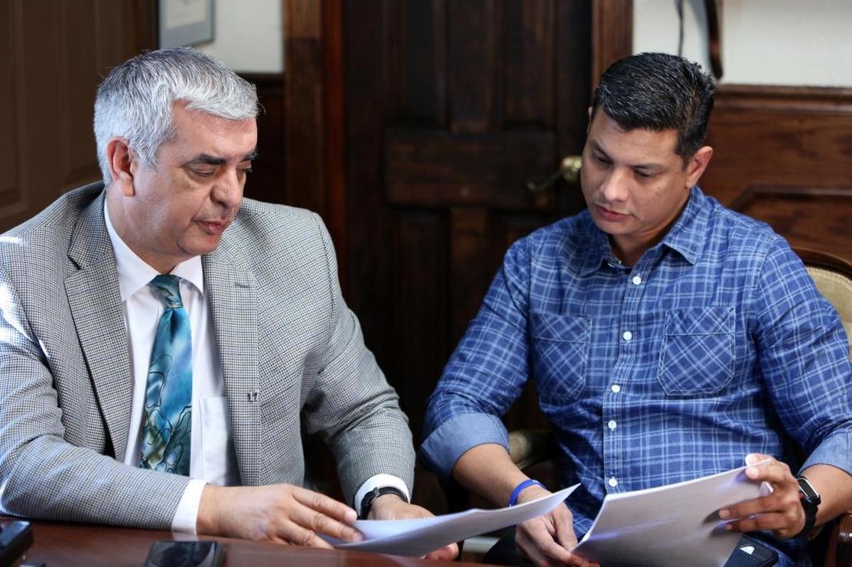 El abogado Alex Arreaza (izq.) y Royer Borges, padre del estudiante Anthony Borges, miran el 28 de marzo de 2017 las mociones presentadas a nombre del joven en una corte de Florida.