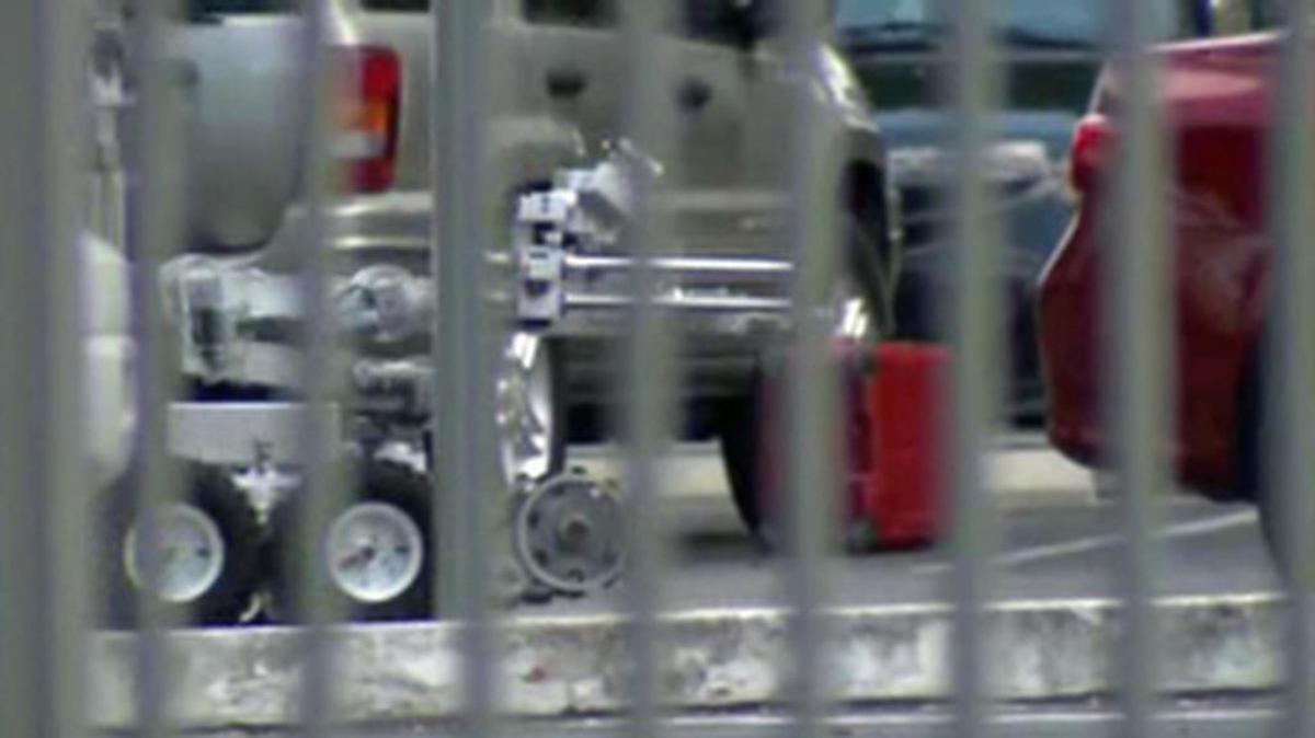 Un robot brigada de explosivos se acerca a una maleta roja, considerada sospechosa después de que fue encontrada abandonada en un estacionamiento en Miami.