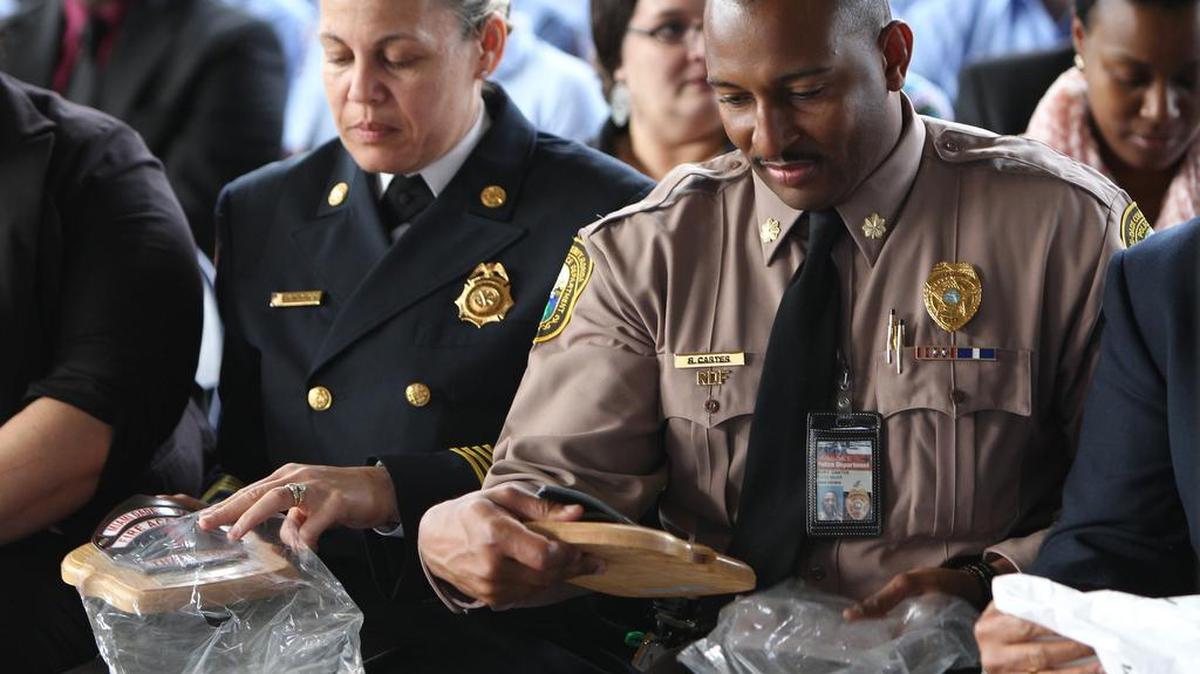 El comandante Ricky Carter (der) recibe una placa en una ceremonia el 8 de enero de 2016 en el Miami-Dade College.