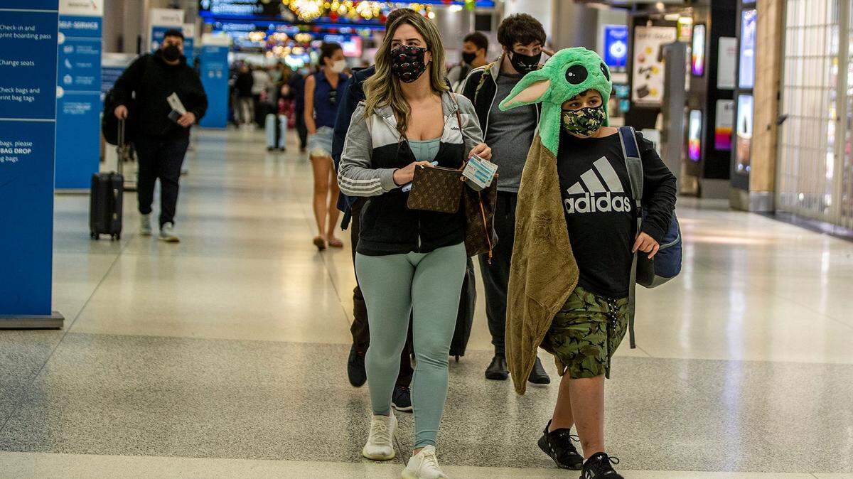Decenas de pasajeros caminan por un pasillo del Aeropuerto Internacional de Miami, el miércoles 23 de diciembre de 2021. El impacto de la variante ómicron en las tripulaciones y empleados de aerolíneas han obligado la cancelación de miles de vuelos en Estados Unidos en los últimos tres días.