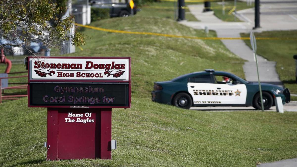 ARCHIVO - Una patrulla policial bloque la entrada a la secundaria Marjory Stoneman Douglas en Parkland, Florida, el 15 de febrero de 2018, un dí­a después de la matanza a tiros de 17 personas entre alumnos y personal a manos de un exestudiante expulsado de esa escuela. (AP Foto/Wilfredo Lee, Archivo)