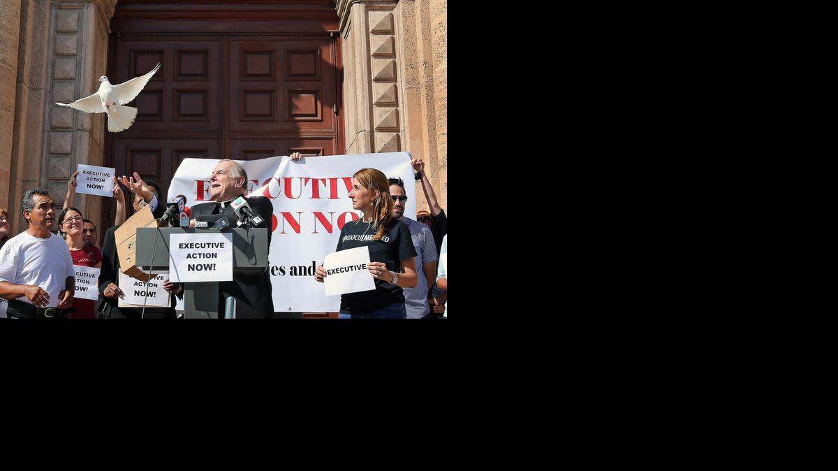 
Thomas Wenski, arzobispo de la arquidiócesis de Miami, libera el jueves una paloma blanca durante una conferencia de prensa a la entrada de la Torre de la Libertad en el downtown de Miami. 
