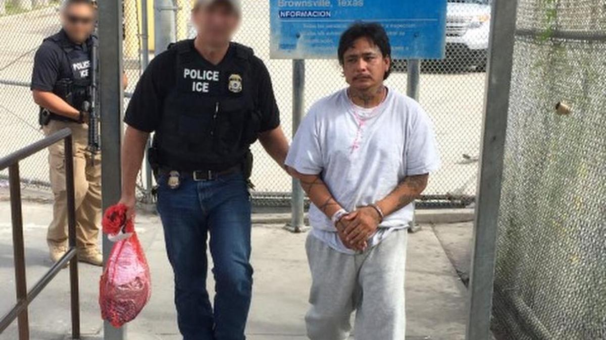 Un miembro de la Policía de Inmigración y Aduanas (ICE) escolta al mexicano Gustavo Pizano Lara, a través del puente fronterizo entre Brownsville, Texas y la ciudad de Matamoros, en el estado mexicano de Tamaulipas.