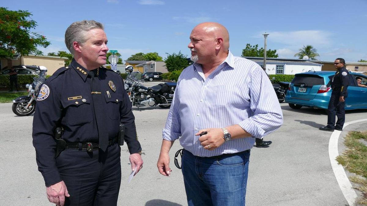 
El jefe de la policía de Sweetwater, Plácido Díaz (izq) , conversa con el alcalde Orlando López durante una actividad el 25 de junio en las calles de la ciudad.
