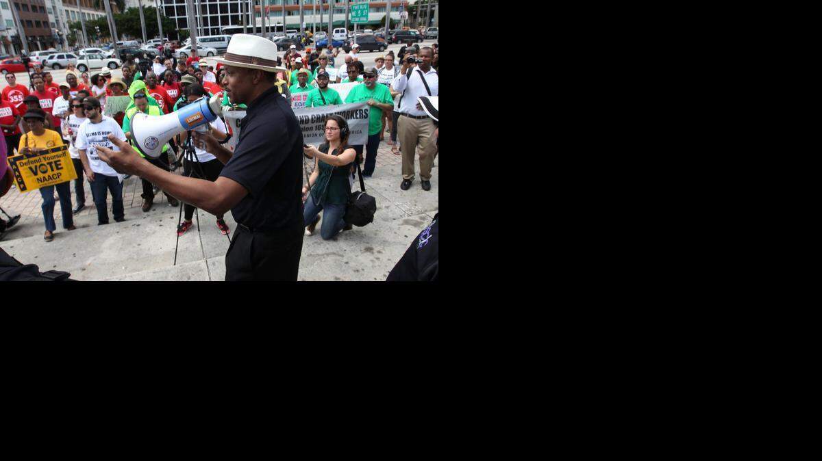 
Gary Johnson (al centro), presidente de la Conferencia Cristiana del Sur, se dirige a los participantes de la marcha el sábado en Overtown.



