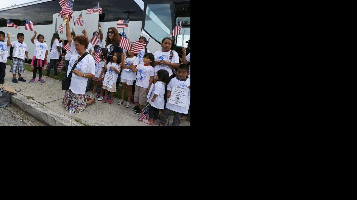 
Alejandra Kelly, de Costa Rica, se arrodilla a rezar  con algunos de los niños que viajan a Washington.


