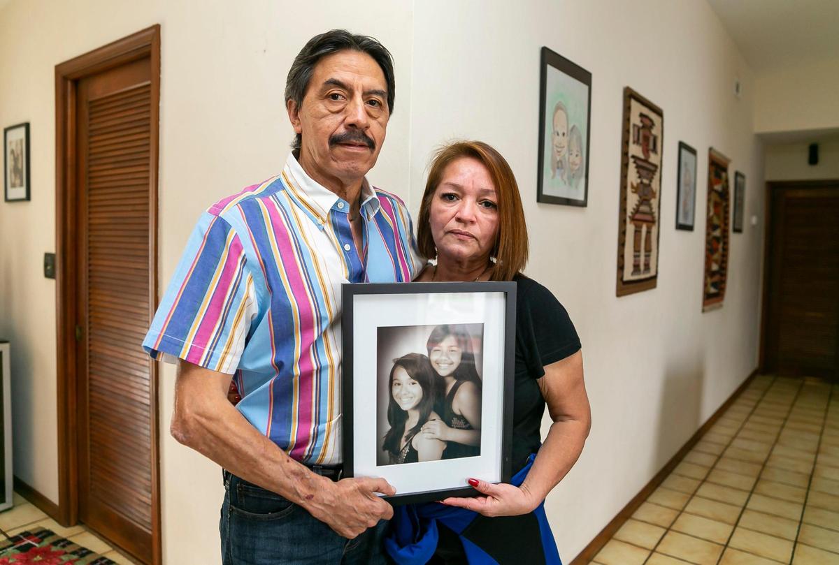 Gina y Orlando Durán sostienen una foto de sus hijas, Dina y Alexa, en su casa en el noroeste de Miami-Dade, el martes 4 de enero de 2022. Alexa Durán, de 18 años, conducía el coche de su padre el día que se derrumbó el puente de la FIU. Ella fue una de las seis personas que murieron en el colapso.