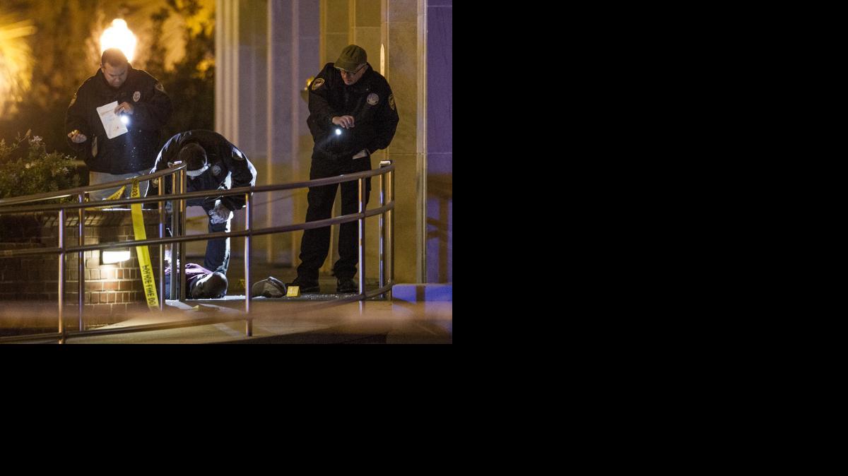 
Agentes de la policía de Tallahassee observan el cadáver del pistolero Myron May, euq yace en el suelo en el exterior de un edificio universitario.


