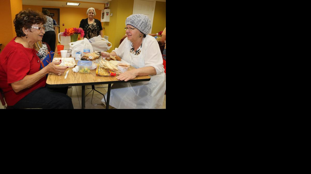 
Personas de edad avanzada como Gladys Artigas (izquierda) y Encarnacion Carballo en el Alex Center de Hialeah, reunidas para comer este martes 23 de Diciembre.
