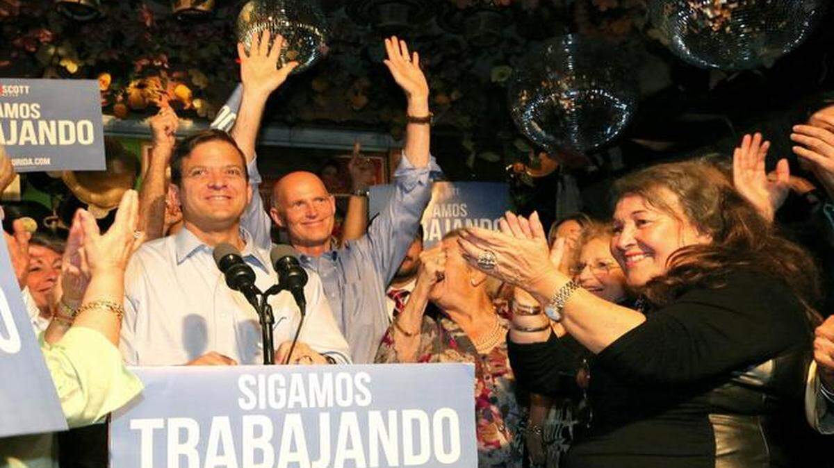 
El gobernador Rick Scott (centro) y el vicegobernador Carlos López-Cantera (izquerda) durante el acto en el restaurante Pueblito Viejo con miembros de la comunidad colombiana.

