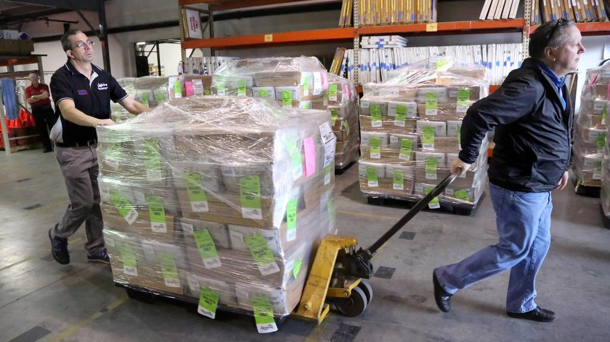 Matt Parri (izq.) y Martin Munro, empleados del Departamento de Elecciones del condado Pinellas, organizan los pallets de boletas de ausentes en un almacén de Largo, el 9 de febrero. “Estamos viendo una acumulación de varios ciclos electorales”, dijo Deborah Clark, Supervisora de Elecciones de Pinellas, quien ha impulsado el voto por correo como algo conveniente desde el 2008.
