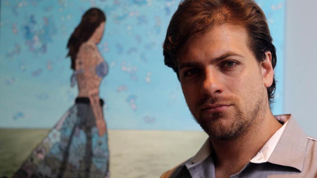 El actor y pintor mexicano Pablo Azar junto a la pieza ‘La niña de los corales’, que forma parte de la exposición ‘Into the Blue’, que se puede ver en el Hotel Aloft de Doral.