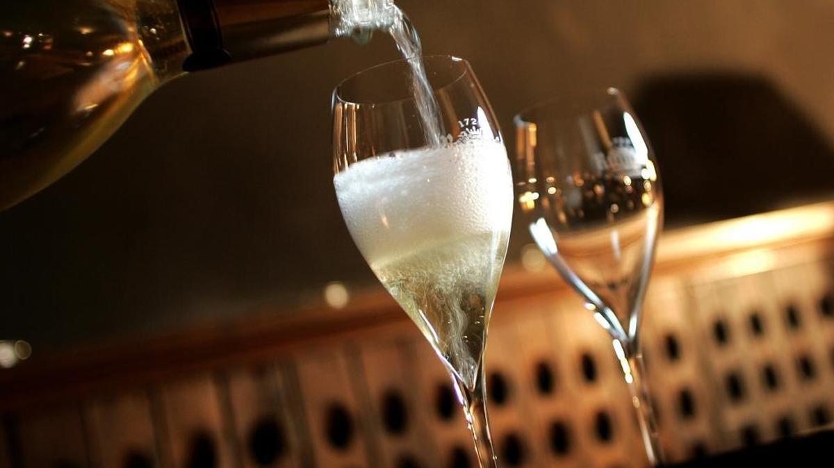 Sirviendo una copa de Champagne para degustar en las bodegas Ruinart, Reims, Francia.