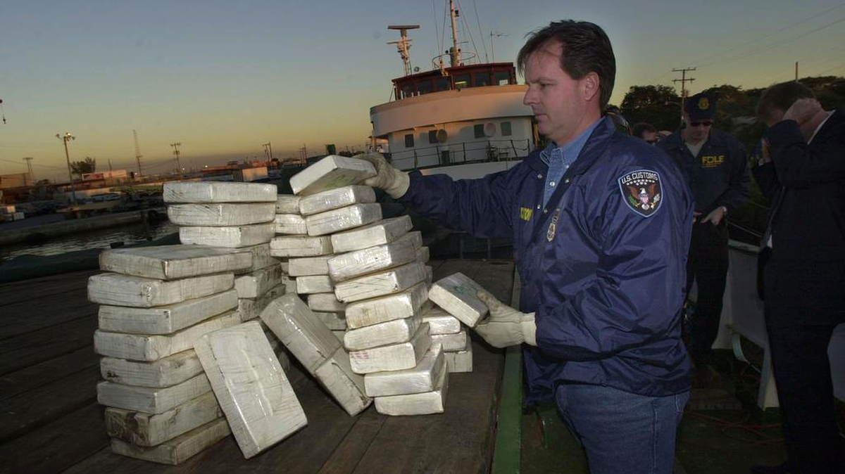 Foto de archivo. Zach Mann, un funcionario de la oficina de aduanas, cuenta los ladrillos de cocaína descubiertos dentro de una embarcación atracada en una marina del río Miami, en enero del 2002. 