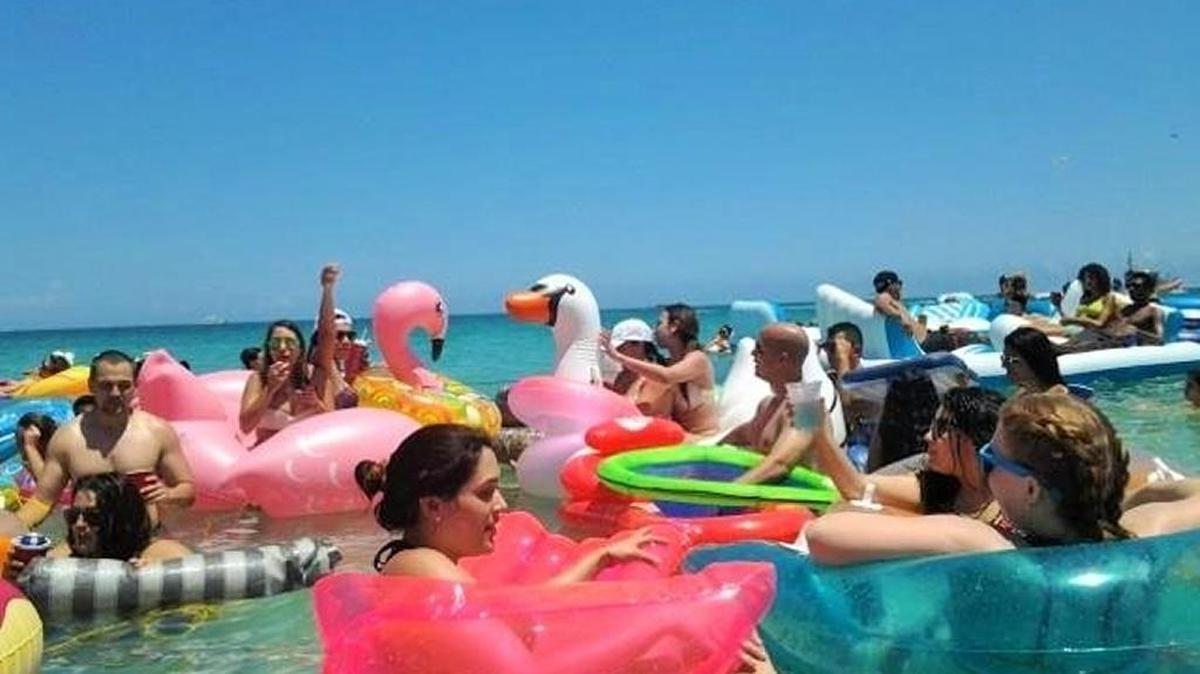 Personas participan en Floatopia cerca de South Pointe Park. en Miami Beach. La gente tre flotadores de todas las formas y tamaños y se flotan en el agua durante todo el día.