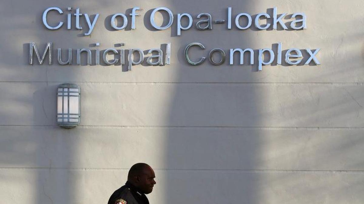 Un agente policial pasa frente al edificio de la municipalidad de la ciudad de Opa-Locka, donde el FBI se incautó docenas de documentos en marzo pasado.