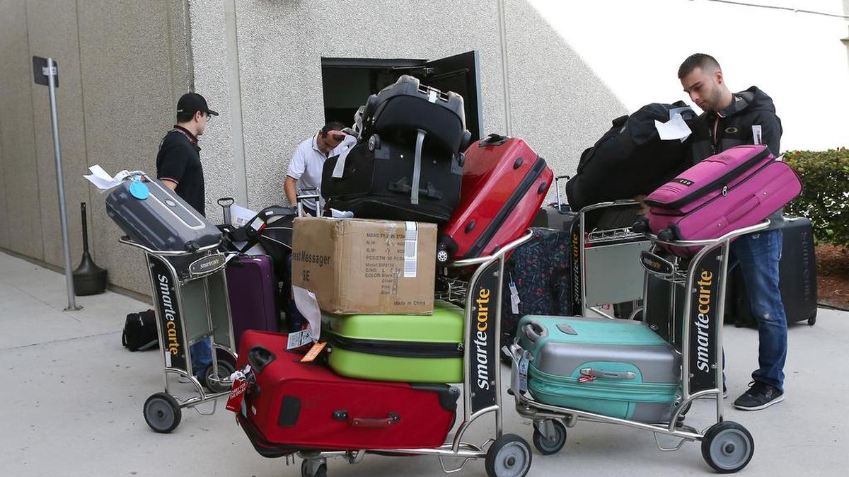 Empleados del Aeropuerto Internacional Fort Lauderdale-Hollywood acomodan maletas que fueron abandonadas durante el tiroteo del viernes, este lunes 9 de enero del 2017.