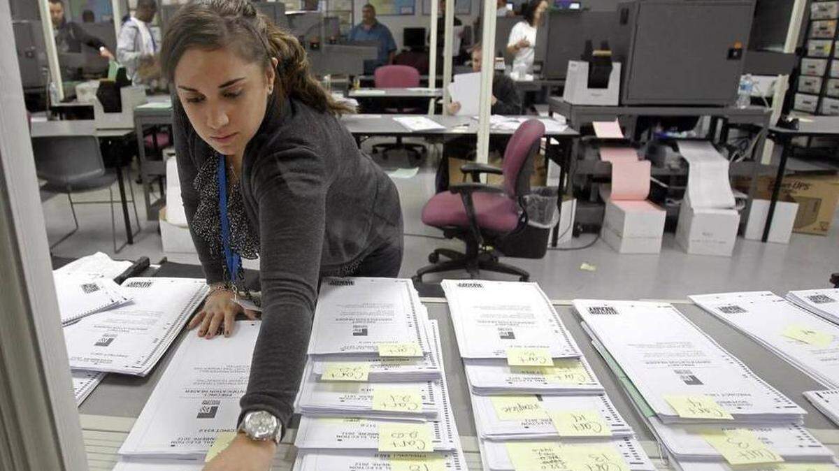 En esta foto de archivo de 2012, una empleada del departamente de elecciones de Miami-Dade marca un grupo de papeletas de voto ausente en Doral. Alan Diaz AP