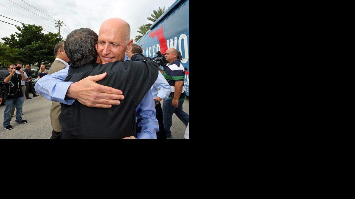 
El gobernador de la Florida, Rick Scott es abrazado por el comisionado del Condado de Dade Comisionado José "Pepe" Díaz en el Anthony Coal Fire Pizza en Doral el Miércoles, 22 de octubre 2014.
