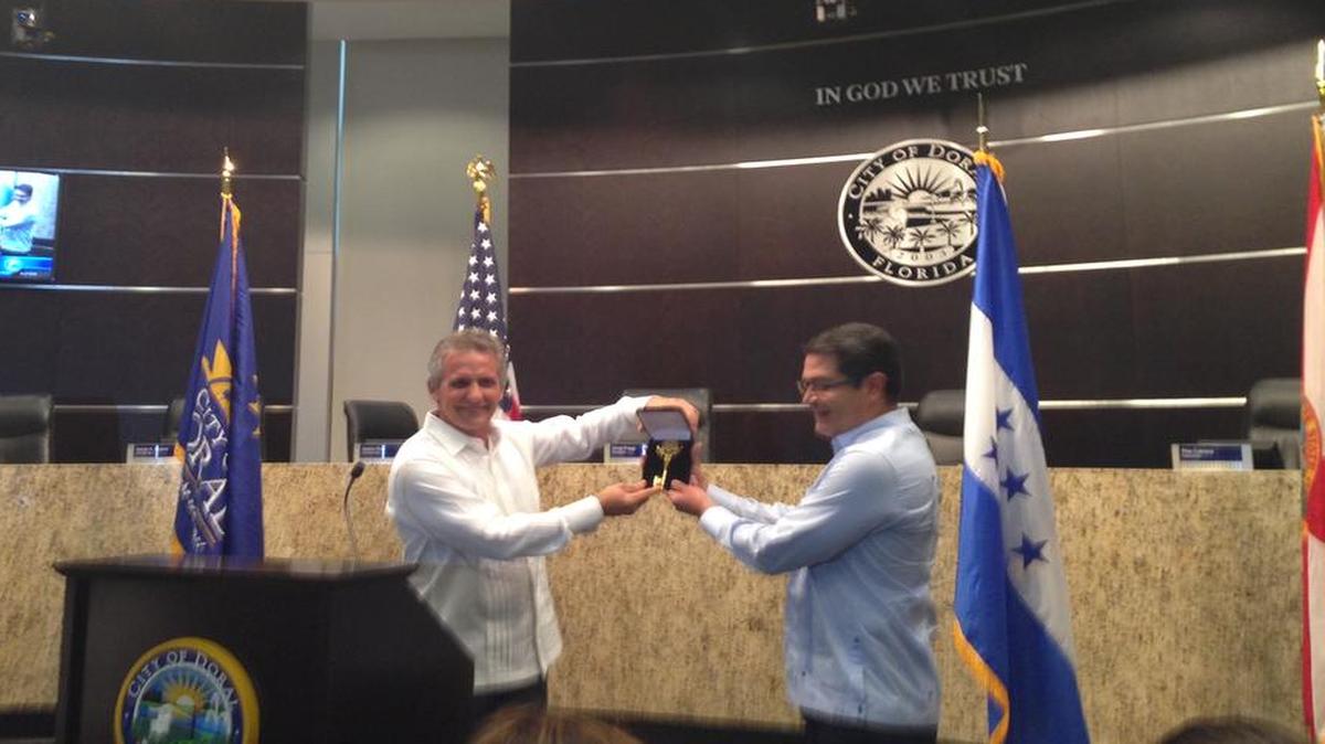 El alcalde de Doral, Luigi Boria (izq.), entre las llaves de la ciudad al presidente de Honduras, Juan Orlando Hernández, el miércoles en la sede del gobierno local.