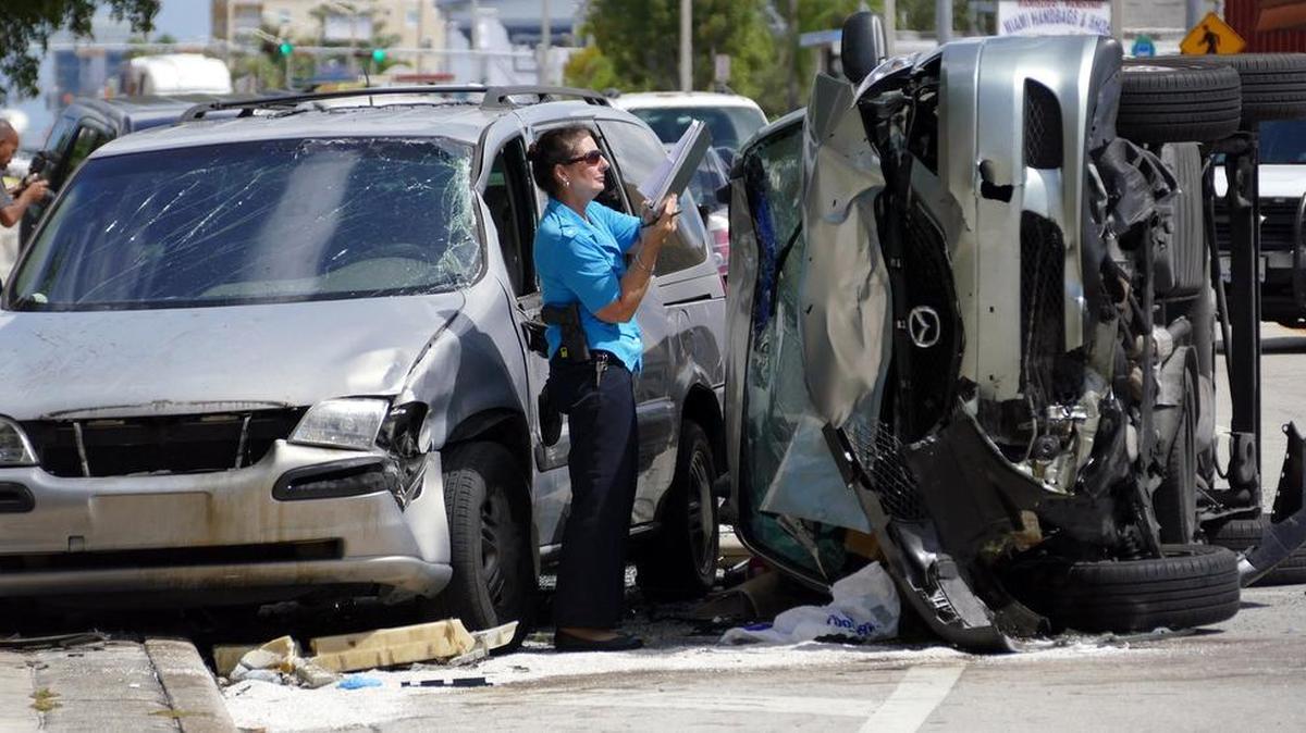 
Un agente de policía examina una furgoneta Mazda involucrada en un choque en donde murieron una persona y ocho resultaron heridas, el miércoles en la Pequeña Habana de Miami. El incidente ocurrió frente Green Spring High School, en NW 7 Street y 35 Avenue. 
