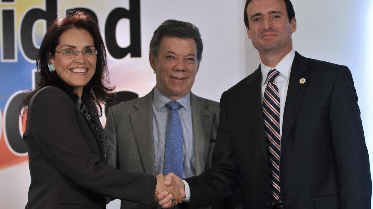 El presidente de Colombia Juan Manuel Santos (cen.) sonríe mientras la fiscal general colombiana Viviane Morales da un apretón de manos al fiscal federal en Miami, Wifredo Ferrer, durante una conferencia de prensa en Bogotá, en el 2011.