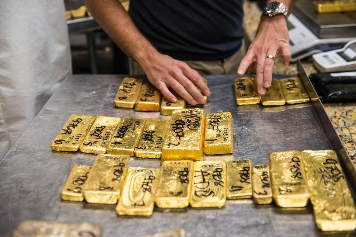 Un empleado cuenta barras de oro antes de someterlas a una prueba de pureza en una instalación en el distrito del oro y los diamentes en centro de Miami el 12 de diciembre del 2014.