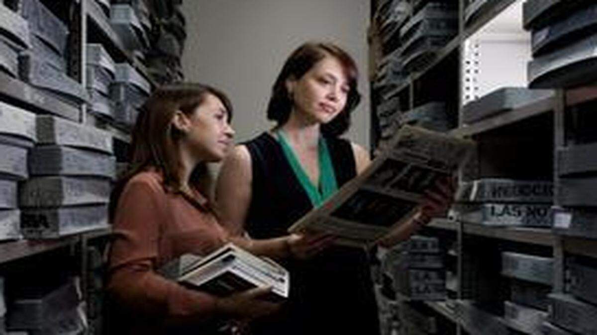 
María R. Estorino (derecha), directora de la Colección de Herencia Cubana de la Universidad de Miami, asiste a una investigadora. 
