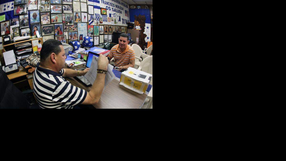 
Francisco Portillo (izq.), Presidente de la Organización Hondureña integrada Francisco Morazan, ayuda a Juan Ramón Méndez a llenar la solicitud para el TPS.
