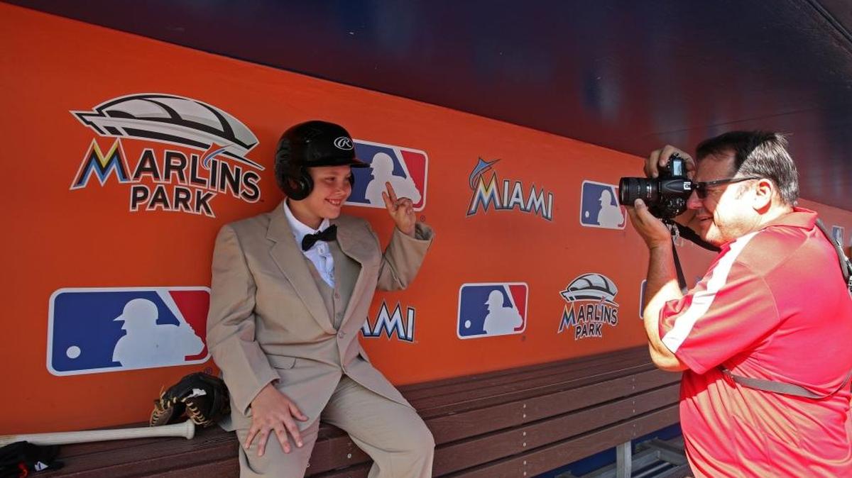 Christopher Buchanan se toma una foto en el banco de los Marlins.