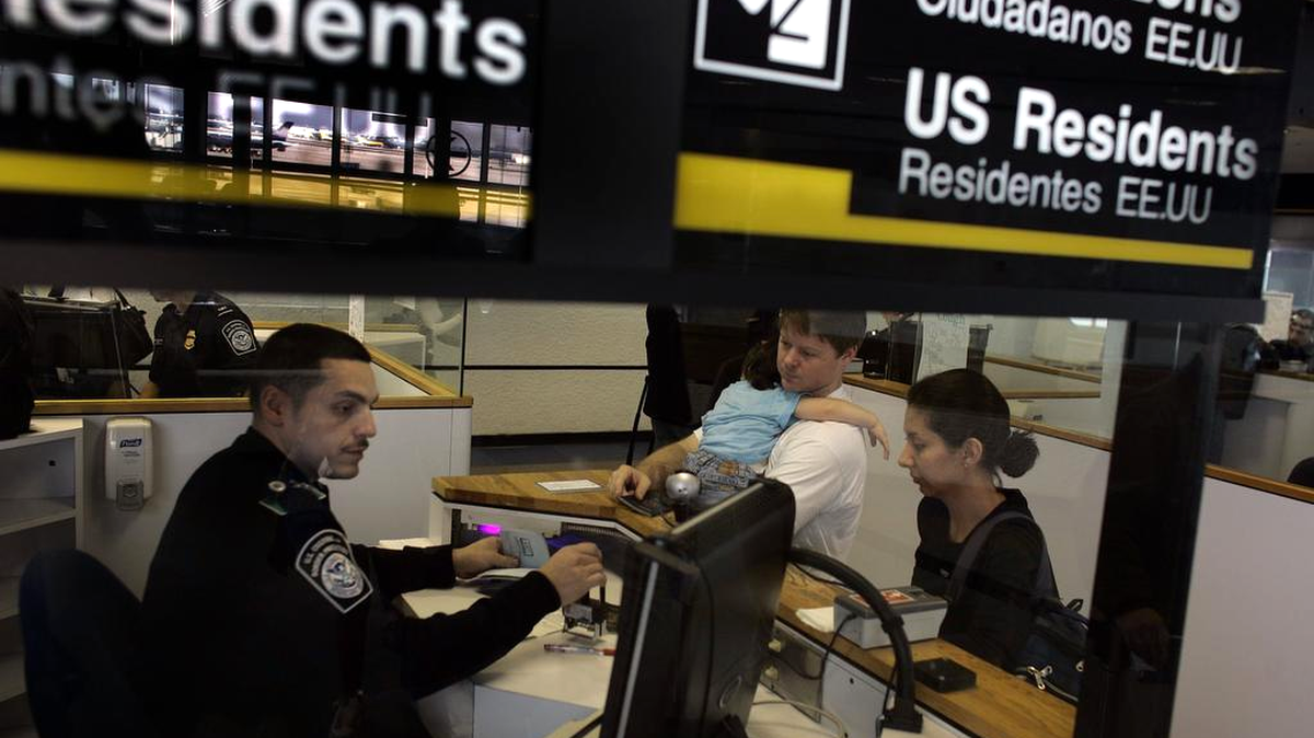 Un funcionario de la oficina de Aduanas y Protección de Fronteras (CBP) verifica los pasaportes de un grupo de viajeros que acaban de llegar al Aeropuerto Internacional de Miami en esta imagen de archivo.