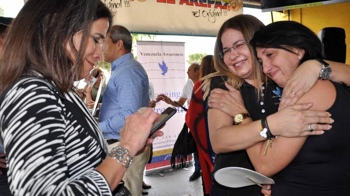 La presidenta de la ONG Venezuela Awareness , Patricia Andrade, (cent.) abraza a María Eugenia Tovar, madre de Génesis Carmona, la reina de belleza que fue asesinada mientras participaba en una manifestación de protesta en Valencia, en febrero del 2014, al término del evento realizado en Doral, donde los venezolanos conmemoraron el Día de los Derechos Humanos.