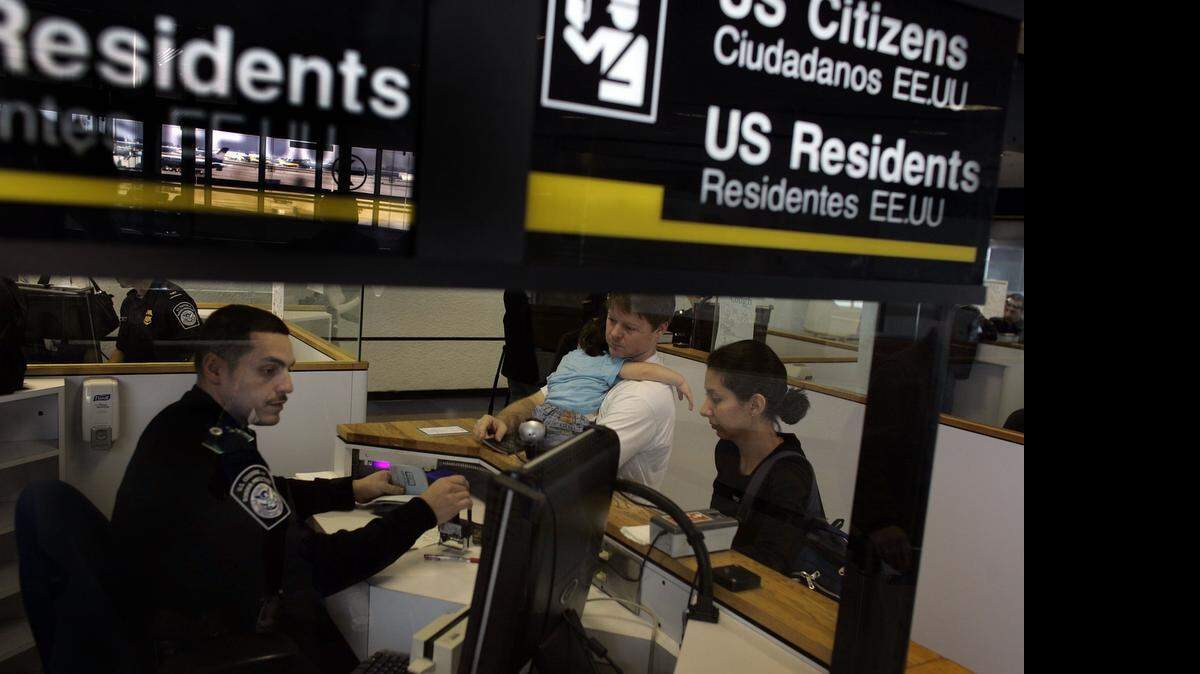 
Anthony Ramos, funcionario de Aduana y Protección Fronteriza, recibe a los viajeros Chris Layman, Katy Layman, de 21 meses, y Natalie Layman en la linea de inmigración del Aeropuerto Internacional de Miami (MIA). 
