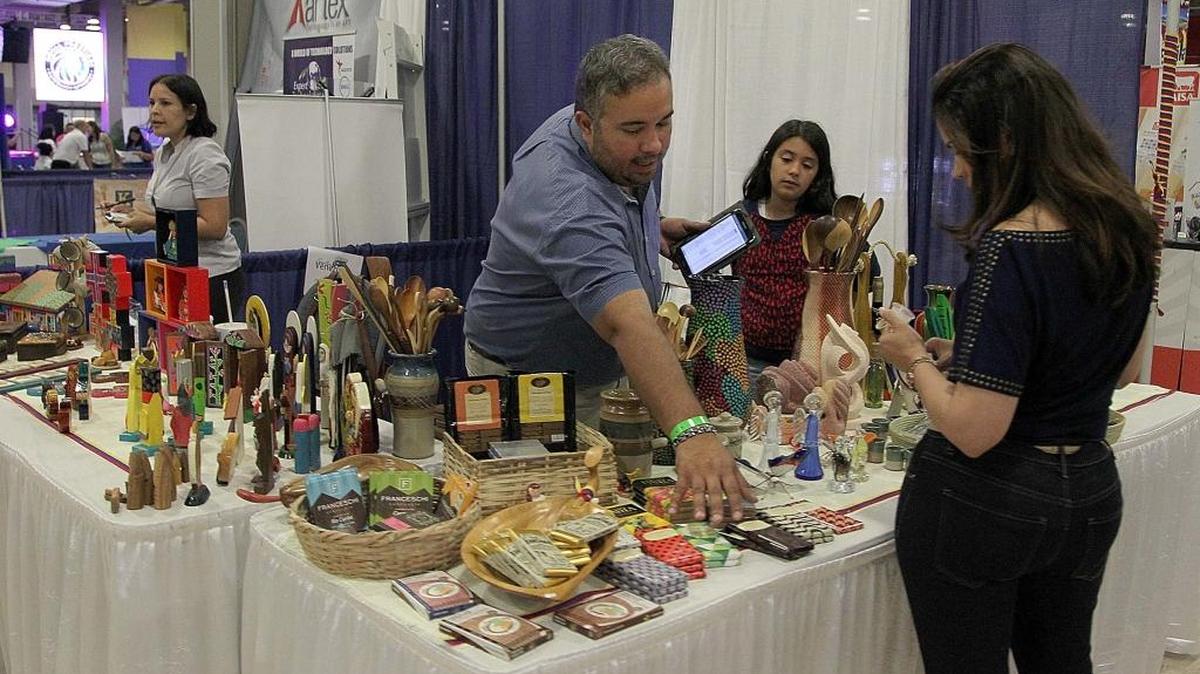 Jesús Hernández y su hija Alba muestran algunos de los productos que vende en el espacio de Encuentra arte Latino, el sábado.