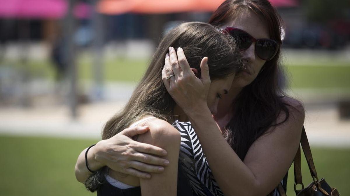Un grupo de personas de reúne a las afueras del Dr. Phillips Center for the Performing Arts para rendir tributo a las víctimas de la matanza de Orlando, en esta ciudad de Florida el lunes 13 de junio de 2016. El ataque ocurrió el pasado domingo en una discoteca gay de la ciudad estadounidense de Orlando, en la que 50 personas murieron.