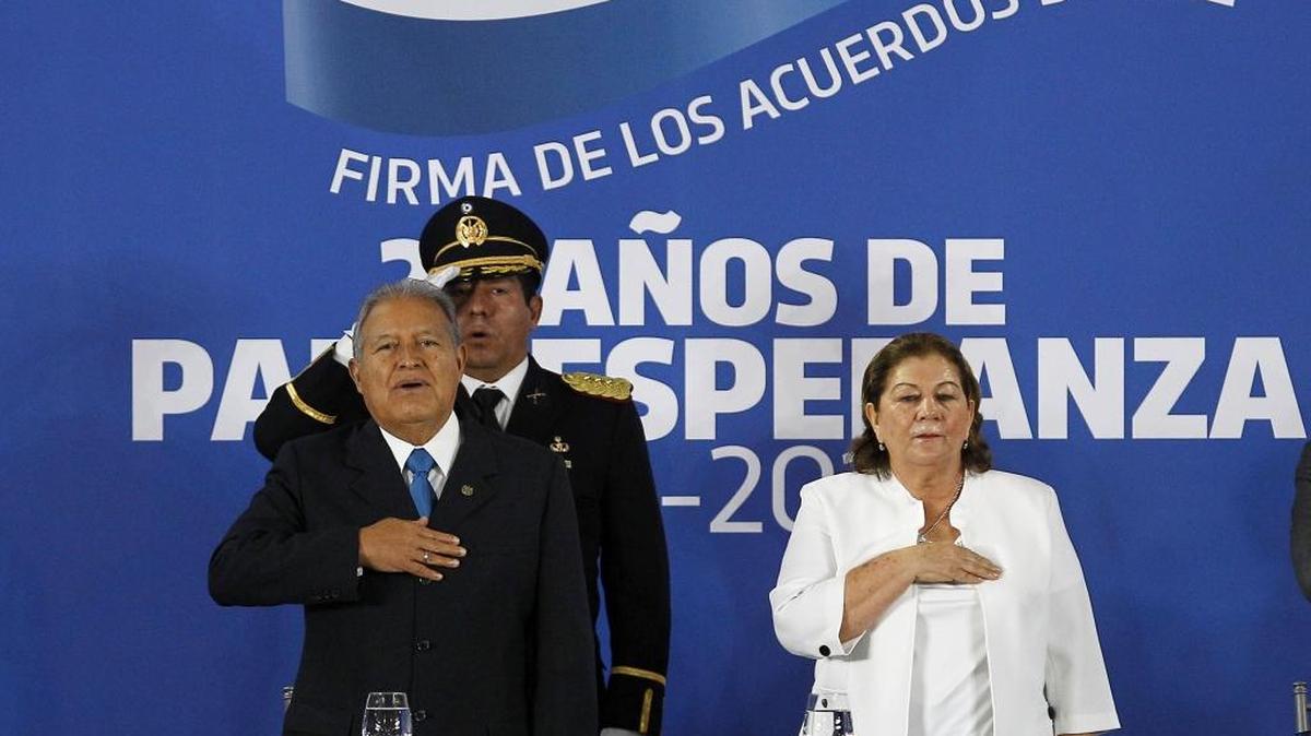 El presidente de El Salvador, Salvador Sánchez Cerén, canta el himno nacional junto a su esposa Margarita Villalta el sábado, durante la conmemoración de los 24 años de la firma de los Acuerdos de Paz, y donde pidió perdón por los crímenes de guerra cometidos por el Ejército durante el conflicto interno que vivió este país entre 1980 y 1992.
