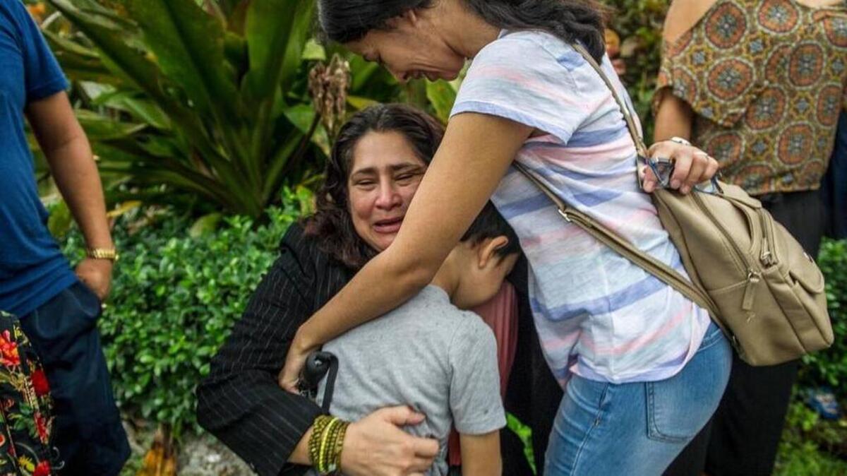 La trabajadora doméstica residente en Estados Unidos Reyna Gómez (cen.) abraza el lunes a amigos tras la decisión del Departamento de Migración y Control de Aduana de Miramar, Broward, de convocarla de nuevo en dos semanas, mientras continúan examinando su caso de petición de asilo.